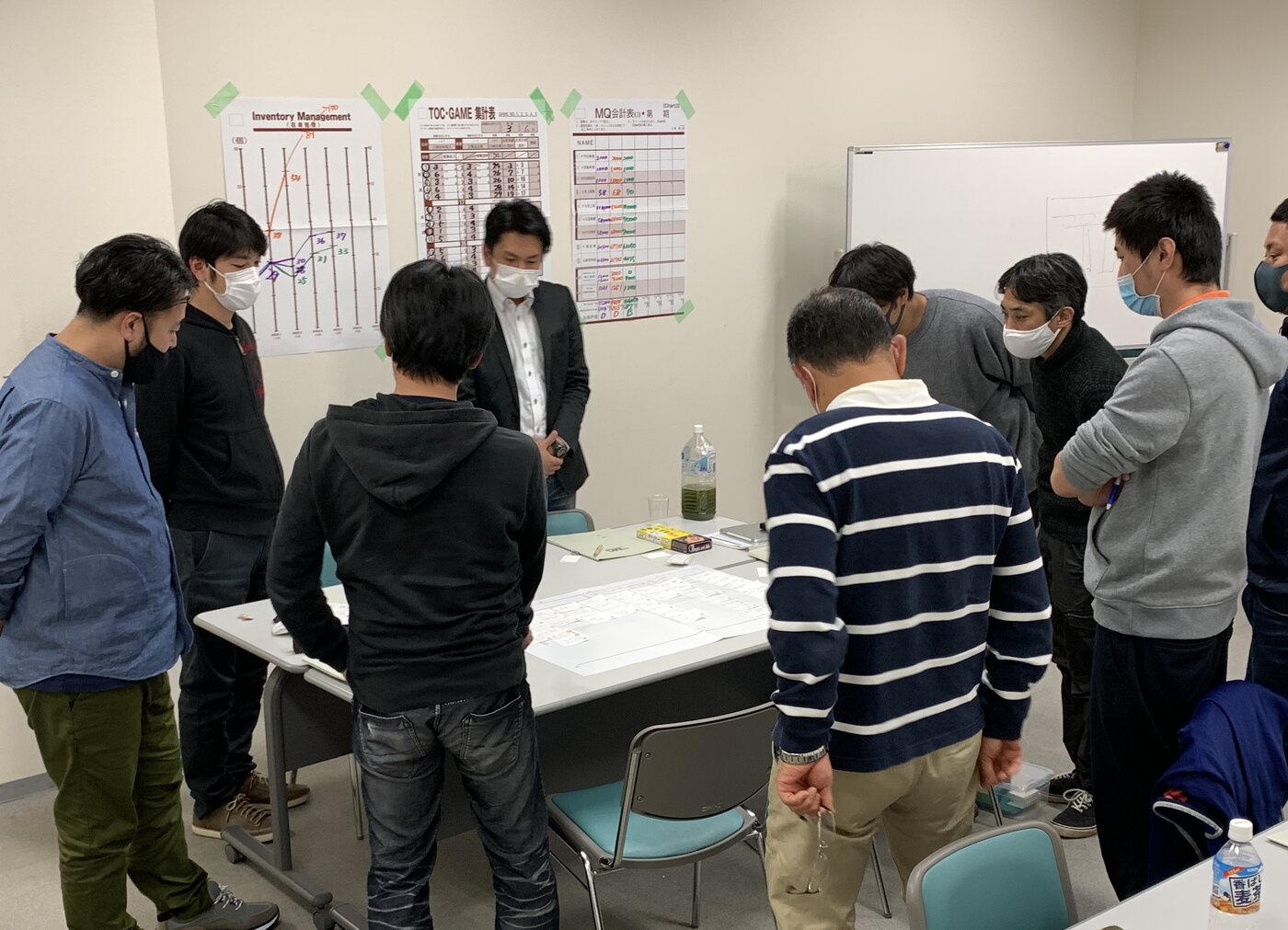 株式会社看板市場のスタッフが資料を囲んで意見を交わす社内研修の様子